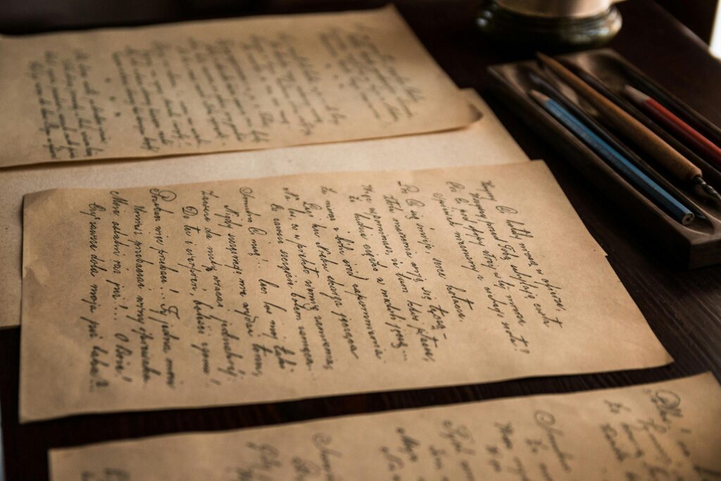 Authentic vintage handwritten letters on a rustic table with pens.