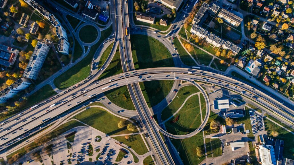 Aerial shot of a complex highway intersection in a vibrant urban cityscape.