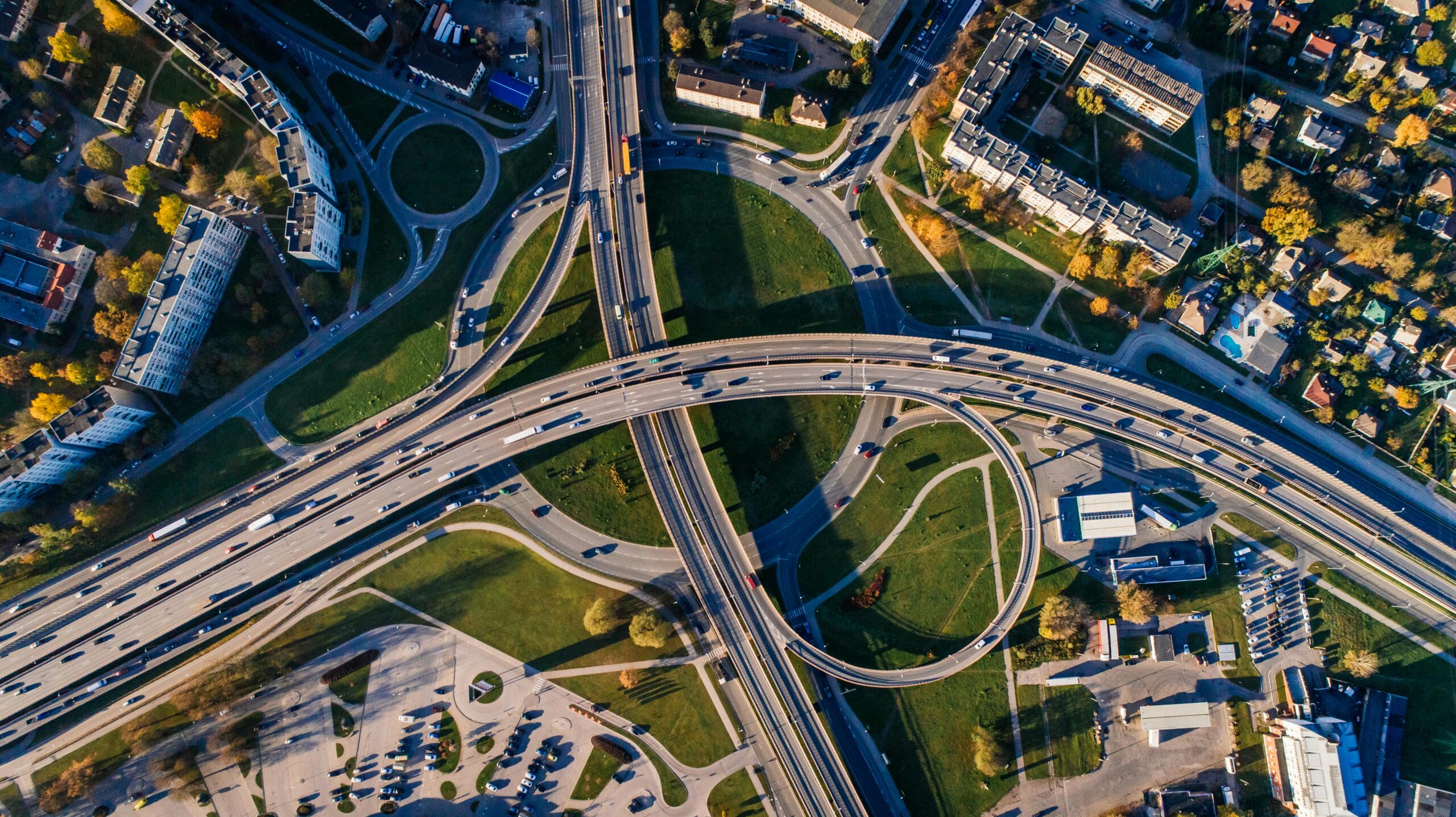 Aerial shot of a complex highway intersection in a vibrant urban cityscape.